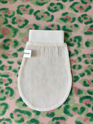 Wildpier white exfoliating glove on a pink and green print